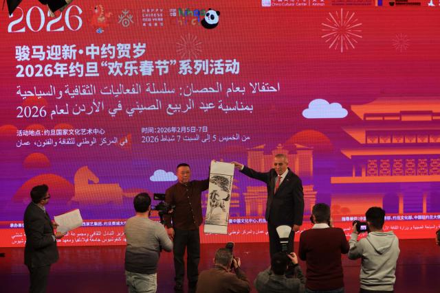 (260206) -- AMMAN, Feb. 6, 2026 (Xinhua) -- Jordanian Minister of Culture Mustafa Al-Rawashdeh (R, back) receives a painting gift from a Chinese artist at the opening ceremony for "Happy Chinese New Year" in Jordan celebrations at the Jordan National Center for Culture and Arts in Amman, Jordan, on Feb. 5, 2026. The 2026 "Happy Chinese New Year" in Jordan celebrations for the Year of the Horse launched on Thursday at the Jordan National Center for Culture and Arts. (Photo by Mohammad Abu Ghosh/Xinhua)