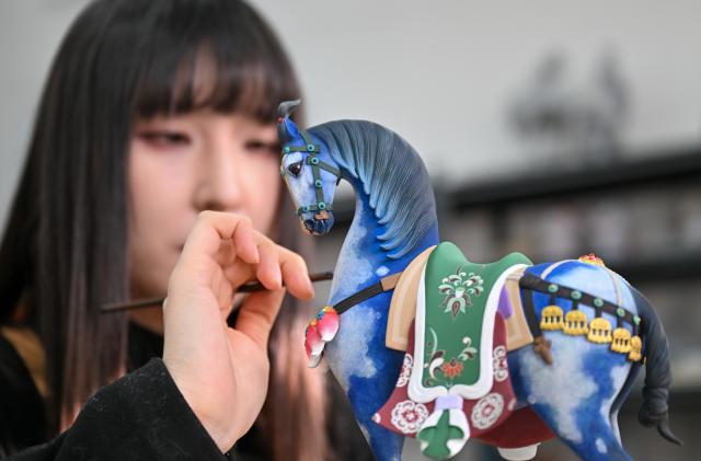 (260206) -- TIANJIN, Feb. 6, 2026 (Xinhua) -- An artist paints a clay figurine at the Tianjin Clay Figurine Zhang Painted Sculpture Working Office in Tianjin, north China, Feb. 5, 2026. The Tianjin Clay Figurine Zhang Painted Sculpture Working Office has recently designed and created a series of painted sculptures themed on the Year of the Horse to greet the Chinese New Year. These artworks will be part of a Year of the Horse themed exhibition at the Tianjin Museum, which will be be open to the public free of charge during the Spring Festival. (Xinhua/Sun Fanyue)