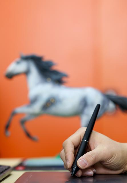 (260206) -- TIANJIN, Feb. 6, 2026 (Xinhua) -- An artist creates with an electronic pen on a computer at the Tianjin Clay Figurine Zhang Painted Sculpture Working Office in Tianjin, north China, Feb. 5, 2026. The Tianjin Clay Figurine Zhang Painted Sculpture Working Office has recently designed and created a series of painted sculptures themed on the Year of the Horse to greet the Chinese New Year. These artworks will be part of a Year of the Horse themed exhibition at the Tianjin Museum, which will be be open to the public free of charge during the Spring Festival. (Xinhua/Sun Fanyue)