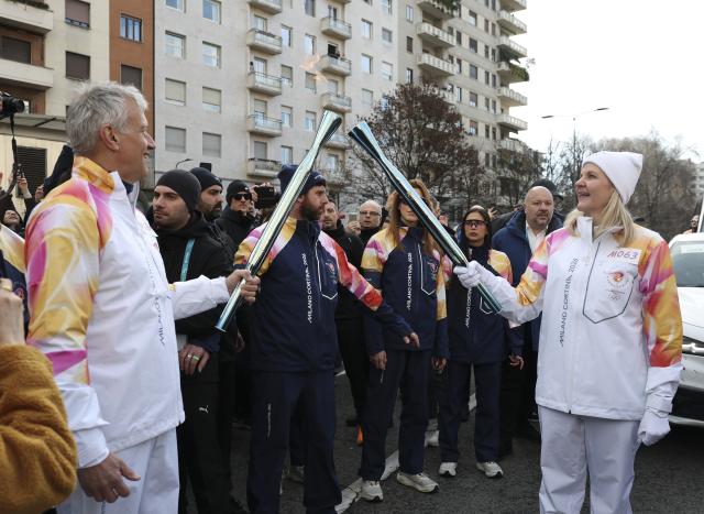 (260206) -- MILAN, Feb. 6, 2026 (Xinhua) -- International Olympic Committee (IOC) President Kirsty Coventry (R) and Coca-Cola CEO James Quincey relay the torch during the torch relay for 2026 Milan-Cortina Winter Olympics in Milan, Italy, Feb. 6, 2026. (Xinhua/Li Jing)