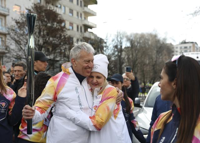 (260206) -- MILAN, Feb. 6, 2026 (Xinhua) -- International Olympic Committee (IOC) President Kirsty Coventry (R) hugs Coca-Cola CEO James Quincey during the torch relay for 2026 Milan-Cortina Winter Olympics in Milan, Italy, Feb. 6, 2026. (Xinhua/Li Jing)