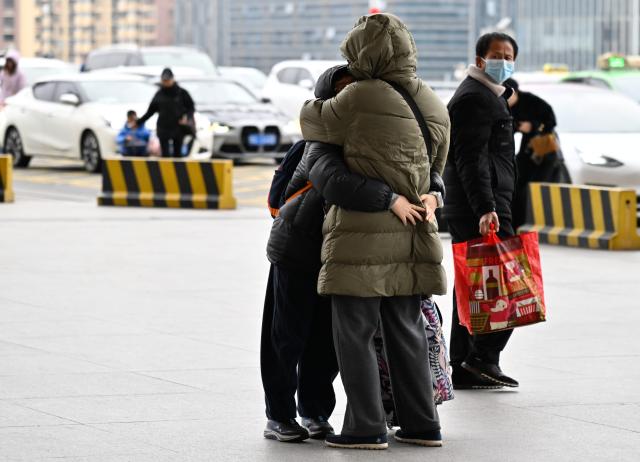 (260206) -- NANJING, Feb. 6, 2026 (Xinhua) -- A child hugs a kin before taking a train at the Nanjing South Railway Station in Nanjing, east China's Jiangsu Province, Feb. 6, 2026. (Xinhua/Ji Chunpeng)