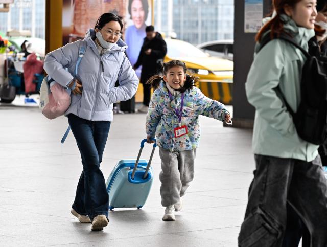 (260206) -- NANJING, Feb. 6, 2026 (Xinhua) -- A girl travelling with her family is about to take a train at the Nanjing South Railway Station in Nanjing, east China's Jiangsu Province, Feb. 6, 2026. (Xinhua/Ji Chunpeng)