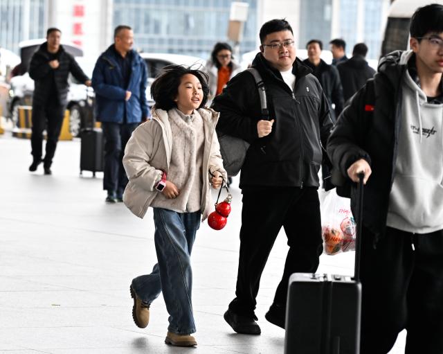 (260206) -- NANJING, Feb. 6, 2026 (Xinhua) -- A girl travelling with her family is about to take a train at the Nanjing South Railway Station in Nanjing, east China's Jiangsu Province, Feb. 6, 2026. (Xinhua/Ji Chunpeng)