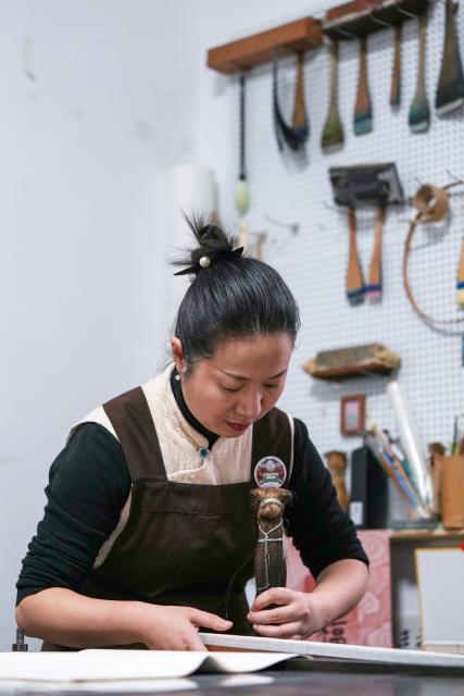 (260206) -- NANJING, Feb. 6, 2026 (Xinhua) -- Qiao Lanrong, an inheritor of Taohuawu woodblock New Year prints, makes a New Year print on the Year of the Horse at her studio in Suzhou, east China's Jiangsu Province, Feb. 5, 2026.
  Suzhou has a time-honored tradition of displaying New Year prints during the Spring Festival. Taohuawu woodblock New Year prints, named after their widespread popularity on Suzhou's Taohuawu Street in ancient times, boast a history of over 400 years. Their crafting technique traces back to the woodblock printing methods of the Song Dynasty (960-1279). Featuring a diverse range of themes, these prints not only express people's best wishes for the new year but also mirror the evolving changes in society. 
   With the Spring Festival approaching, Taohuawu woodblock New Year prints have been updated with fresh designs featuring the Year of the Horse elements. An exhibition of these prints is also being held at the Suzhou Art Museum. Meanwhile people can experience the prints making process in person and purchase cultural and creative products at a promotion center of Taohuawu woodblock New Year prints. (Xinhua/Li Bo)