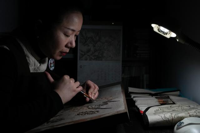 (260206) -- NANJING, Feb. 6, 2026 (Xinhua) -- Qiao Lanrong, an inheritor of Taohuawu woodblock New Year prints, makes a woodblock for New Year prints at her studio in Suzhou, east China's Jiangsu Province, Feb. 5, 2026.
  Suzhou has a time-honored tradition of displaying New Year prints during the Spring Festival. Taohuawu woodblock New Year prints, named after their widespread popularity on Suzhou's Taohuawu Street in ancient times, boast a history of over 400 years. Their crafting technique traces back to the woodblock printing methods of the Song Dynasty (960-1279). Featuring a diverse range of themes, these prints not only express people's best wishes for the new year but also mirror the evolving changes in society. 
   With the Spring Festival approaching, Taohuawu woodblock New Year prints have been updated with fresh designs featuring the Year of the Horse elements. An exhibition of these prints is also being held at the Suzhou Art Museum. Meanwhile people can experience the prints making process in person and purchase cultural and creative products at a promotion center of Taohuawu woodblock New Year prints. (Xinhua/Li Bo)