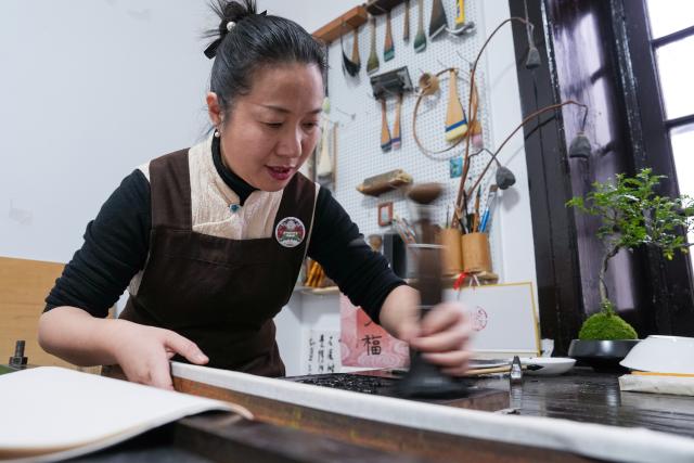 (260206) -- NANJING, Feb. 6, 2026 (Xinhua) -- Qiao Lanrong, an inheritor of Taohuawu woodblock New Year prints, makes a New Year print on the Year of the Horse at her studio in Suzhou, east China's Jiangsu Province, Feb. 5, 2026.
  Suzhou has a time-honored tradition of displaying New Year prints during the Spring Festival. Taohuawu woodblock New Year prints, named after their widespread popularity on Suzhou's Taohuawu Street in ancient times, boast a history of over 400 years. Their crafting technique traces back to the woodblock printing methods of the Song Dynasty (960-1279). Featuring a diverse range of themes, these prints not only express people's best wishes for the new year but also mirror the evolving changes in society. 
   With the Spring Festival approaching, Taohuawu woodblock New Year prints have been updated with fresh designs featuring the Year of the Horse elements. An exhibition of these prints is also being held at the Suzhou Art Museum. Meanwhile people can experience the prints making process in person and purchase cultural and creative products at a promotion center of Taohuawu woodblock New Year prints. (Xinhua/Li Bo)