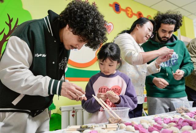 (260206) -- YINCHUAN, Feb. 6, 2026 (Xinhua) -- International students of North Minzu University make dumplings together with local residents in Yinchuan, northwest China's Ningxia Hui Autonomous Region, Feb. 5, 2026. As the Spring Festival approaches, international students from North Minzu University were invited to a community in Yinchuan to experience traditional Chinese folk customs and share the festive joy of the Chinese New Year with local residents. (Xinhua/Yang Zhisen)