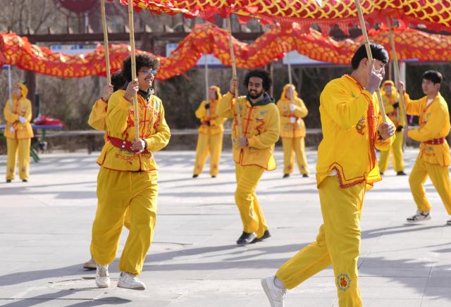 (260206) -- YINCHUAN, Feb. 6, 2026 (Xinhua) -- International students of North Minzu University experience dragon dance in Yinchuan, northwest China's Ningxia Hui Autonomous Region, Feb. 5, 2026. As the Spring Festival approaches, international students from North Minzu University were invited to a community in Yinchuan to experience traditional Chinese folk customs and share the festive joy of the Chinese New Year with local residents. (Xinhua/Yang Zhisen)