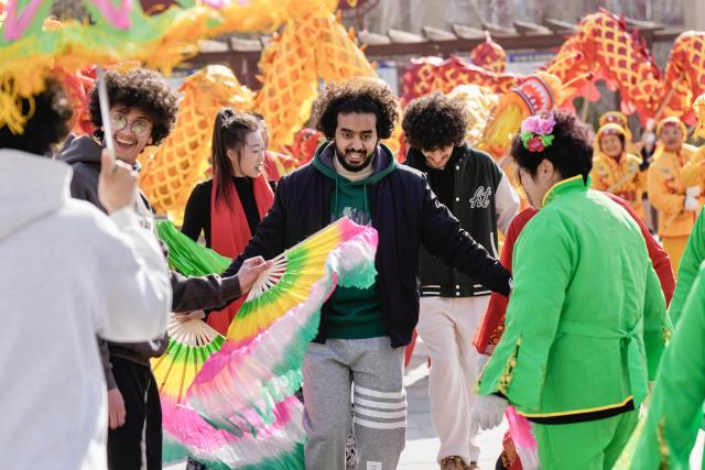 (260206) -- YINCHUAN, Feb. 6, 2026 (Xinhua) -- International students of North Minzu University experience Yangge dance with local residents in Yinchuan, northwest China's Ningxia Hui Autonomous Region, Feb. 5, 2026. As the Spring Festival approaches, international students from North Minzu University were invited to a community in Yinchuan to experience traditional Chinese folk customs and share the festive joy of the Chinese New Year with local residents. (Xinhua/Yang Zhisen)