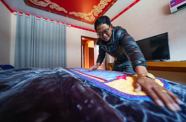 (260206) -- SHANNAN, Feb. 6, 2026 (Xinhua) -- A villager makes bed in a room at his home-stay in Yumai Town of Lhunze County in Shannan City, southwest China's Xizang Autonomous Region, Feb. 5, 2026. Yumai Town, located on the southern foot of the Himalayas, was once home to merely three permanent residents due to its harsh and rugged terrain. Today, residential houses here are neatly arranged, with comprehensive infrastructure including drainage and communication facilities in place. 
   Schools, health clinics, and hotels have also been established, alongside with home-stays, small shops, and courier stations operated by villagers.
   In 2025, the area received over 12,000 tourists, with home-stay income exceeding 284,200 yuan. (Xinhua/Tenzin Nyida)