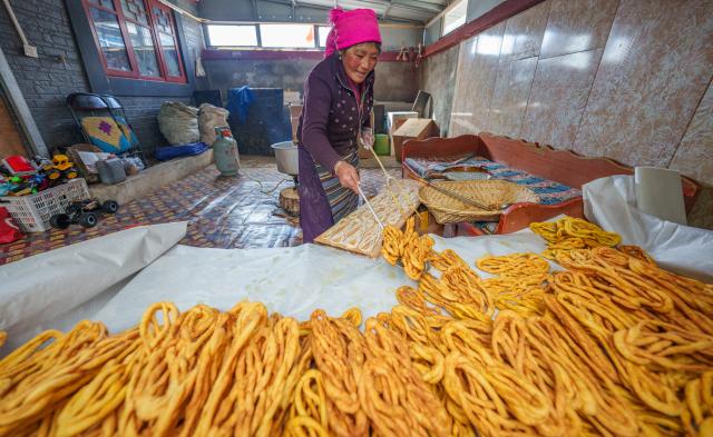 (260206) -- SHANNAN, Feb. 6, 2026 (Xinhua) -- A villager makes traditional snacks for the upcoming Tibetan New Year at home in Yumai Town of Lhunze County in Shannan City, southwest China's Xizang Autonomous Region, Feb. 5, 2026. Yumai Town, located on the southern foot of the Himalayas, was once home to merely three permanent residents due to its harsh and rugged terrain. Today, residential houses here are neatly arranged, with comprehensive infrastructure including drainage and communication facilities in place. 
   Schools, health clinics, and hotels have also been established, alongside with home-stays, small shops, and courier stations operated by villagers.
   In 2025, the area received over 12,000 tourists, with home-stay income exceeding 284,200 yuan. (Xinhua/Tenzin Nyida)