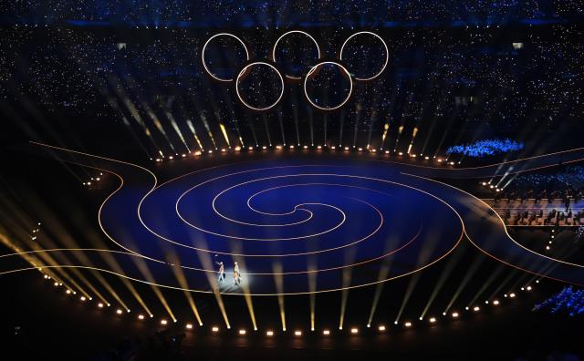 (260207) -- MILAN, Feb. 7, 2026 (Xinhua) -- Torchbearers run with the Olympic flame during the opening ceremony of the Milan-Cortina 2026 Olympic Winter Games at the San Siro Olympic Stadium in Milan, Italy, Feb. 6, 2026. (Xinhua/Xue Yuge)
