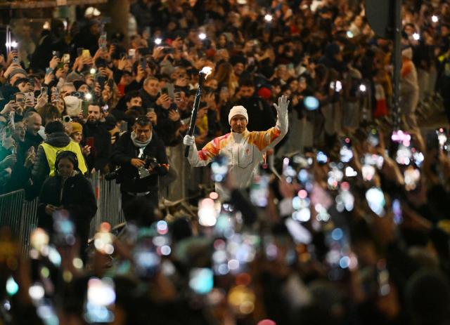 (260207) -- MILAN, Feb. 7, 2026 (Xinhua) -- Torchbearer passes the torch during the opening ceremony of the Milan-Cortina 2026 Olympic Winter Games in Milan, Italy, Feb. 6, 2026. (Xinhua/Wu Wei)