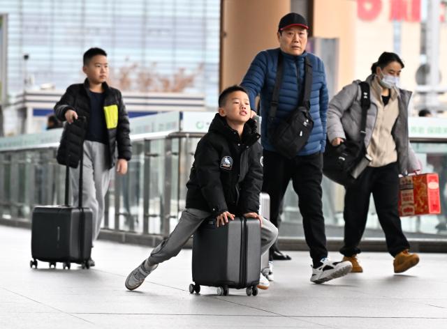 (260207) -- BEIJING, Feb. 7, 2026 (Xinhua) -- Children travelling with their families are about to take a train at the Nanjing South Railway Station in Nanjing, east China's Jiangsu Province, Feb. 6, 2026. (Xinhua/Ji Chunpeng)