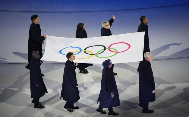 (260207) -- MILAN, Feb. 7, 2026 (Xinhua) -- Flag bearers carry the Olympic flag into the San Siro Olympic Stadium during the opening ceremony of the Milan-Cortina 2026 Olympic Winter Games at the San Siro Olympic Stadium in Milan, Italy, Feb. 6, 2026. (Xinhua/Lai Xiangdong)