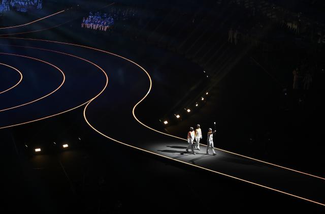 (260207) -- MILAN, Feb. 7, 2026 (Xinhua) -- Torchbearers run with the Olympic flame during the opening ceremony of the Milan-Cortina 2026 Olympic Winter Games at the San Siro Olympic Stadium in Milan, Italy, Feb. 6, 2026. (Xinhua/Zhang Haofu)