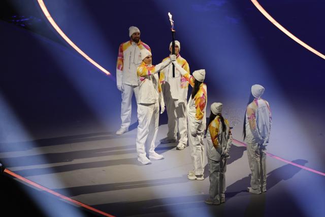 (260207) -- MILAN, Feb. 7, 2026 (Xinhua) -- Torchbearers pass the flame during the opening ceremony of the Milan-Cortina 2026 Olympic Winter Games at the San Siro Olympic Stadium in Milan, Italy, Feb. 6, 2026. (Xinhua/Wang Kaiyan)