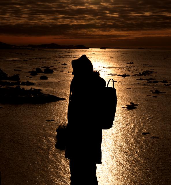 (260207) -- NUUK, Feb. 7, 2026 (Xinhua) -- A woman stands in the light at sunset in Nuuk, Greenland, an autonomous territory of Denmark, Feb. 6, 2026. (Xinhua/Li Ying)