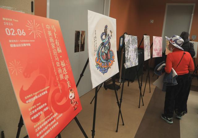 (260207) -- SAN FRANCISCO, Feb. 7, 2026 (Xinhua) -- A woman watches Chinese artworks during a cultural event in San Francisco, the United States, Feb. 6, 2026. A gala combining Chinese artworks, calligraphy, folk music and tea ceremony was held at the San Francisco Public Library to greet the upcoming Chinese New Year, the Year of the Horse, on Friday. (Photo by Liu Yilin/Xinhua)