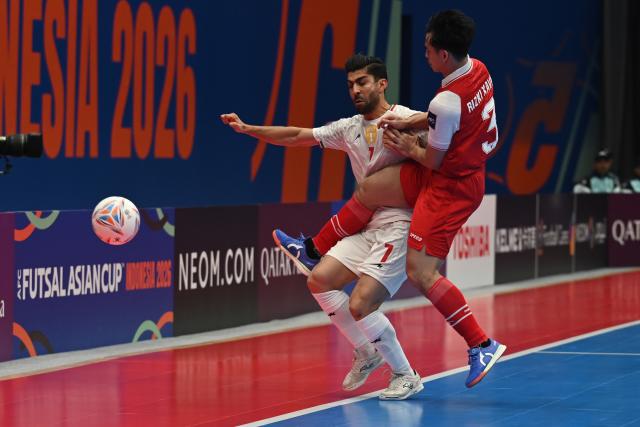 (260207) -- JAKARTA, Feb. 7, 2026 (Xinhua) -- Mahdi Karimi (L) of Iran vies with Muhammad Rizki Xavier of Indonesia during the final match between Indonesia and Iran at the AFC Futsal Asian Cup 2026 in The Indonesia Arena stadium, Jakarta, Indonesia, Feb. 7, 2026. (Xinhua/Agung Kuncahya B.)