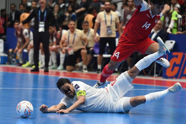 (260207) -- JAKARTA, Feb. 7, 2026 (Xinhua) -- Hossein Tayebibidgoli (L) of Iran vies with Yogi Saputra of Indonesia during the final match between Indonesia and Iran at the AFC Futsal Asian Cup 2026 in The Indonesia Arena stadium, Jakarta, Indonesia, Feb. 7, 2026. (Xinhua/Agung Kuncahya B.)