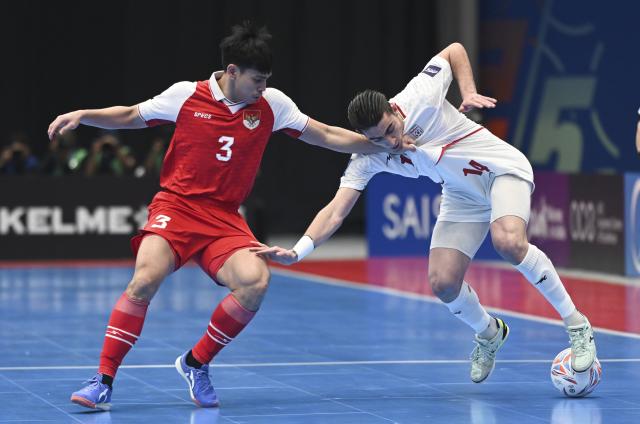 (260207) -- JAKARTA, Feb. 7, 2026 (Xinhua) -- Muhammad Rizki Xavier (L) of Indonesia vies with Behrooz Azimihematabadi of Iran during the final match between Indonesia and Iran at the AFC Futsal Asian Cup 2026 in The Indonesia Arena stadium, Jakarta, Indonesia, Feb. 7, 2026. (Xinhua/Zulkarnain)