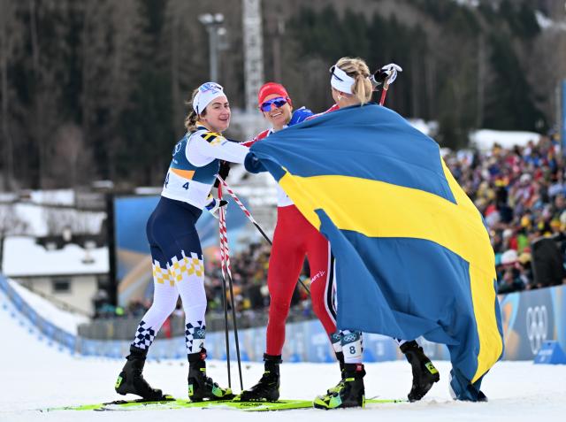 (260207) -- TESERO, Feb. 7, 2026 (Xinhua) -- Frida Karlsson (R) of Sweden, her teammate Ebba Andersson (L), and Heidi Weng of Norway celebrate after the Cross-Country Skiing Women's 10km+10km Skiathlon of the Milan-Cortina 2026 Olympic Winter Games in Tesero, Italy, Feb. 7, 2026. (Xinhua/He Canling)