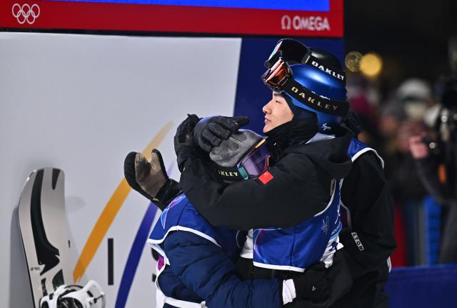 (260207) -- LIVIGNO, Feb. 7, 2026 (Xinhua) -- Su Yiming (R) of China hugs Kimata Ryoma of Japan after the Men's Snowboard Big Air Final at the Milan-Cortina 2026 Olympic Winter Games in Livigno, Italy, Feb. 7, 2026. (Xinhua/Zhang Hongxiang)