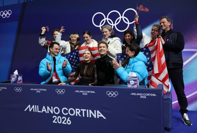 (260208) -- MILAN, Feb. 8, 2026 (Xinhua) -- Madison Chock (front 2nd L)/Evan Bates (front 2nd R) of the United States react to their scores after performing during the free dance of ice dance skating for figure skating team event at the Milan-Cortina 2026 Olympic Winter Games in Milan, Italy, Feb. 7, 2026. (Xinhua/Chen Yichen)