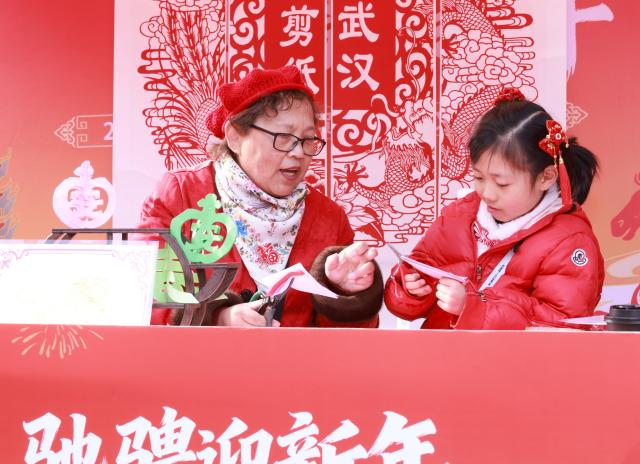 (260208) -- BEIJING, Feb. 8, 2026 (Xinhua) -- An inheritor of intangible cultural heritage shows paper-cutting skills in Wuhan, central China's Hubei Province, Feb. 7, 2026.
  As the Spring Festival approaches, various activities featuring time-honored traditions are held across the country, filling the air with great excitement. (Photo by Zhao Jun/Xinhua)