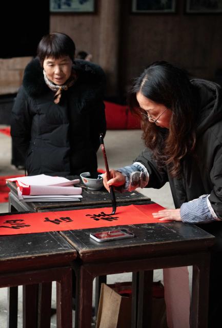 (260208) -- YIXIAN, Feb. 8, 2026 (Xinhua) -- Villagers write spring couplets in Nanping Village of Yixian County, east China's Anhui Province, Feb. 6, 2026.
  Ancient villages in Yixian County are filled with festive vibe as the Spring Festival approaches. Locals follow folk customs by making steamed rice cakes, fish lanterns, and writing spring couplets, drawing tourists to share the festive joy together. (Xinhua/Zhang Duan)