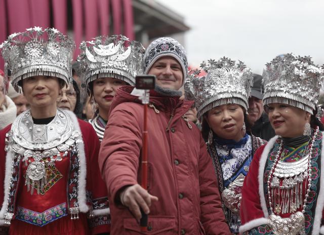 (260208) -- BUDAPEST, Feb. 8, 2026 (Xinhua) -- A man takes a selfie with performers in traditional costumes during the Budapest Chinatown Spring Festival Temple Fair in Budapest, Hungary, on Feb. 7, 2026. TO GO WITH "Feature: Budapest embraces Chinese Spring Festival as cultural bridge between civilizations" (Photo by Laszlo Balogh/Xinhua)