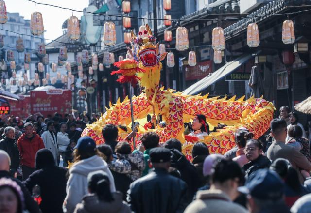 (260208) -- JIANDE, Feb. 8, 2026 (Xinhua) -- Tourists watch traditional dragon dance at Shouchang ancient town in Jiande, east China's Zhejiang Province, Feb. 8, 2026. Shouchang ancient town has recently held traditional folk activities such as folk parades, dragon and lion dances, and a lantern show to welcome the Chinese New Year. (Xinhua/Xu Yu)