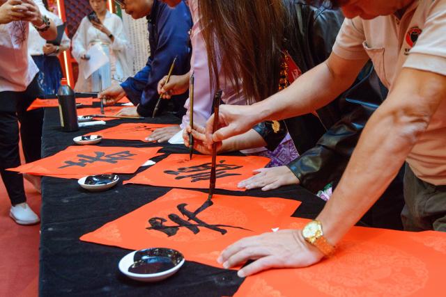 (260208) -- KUALA LUMPUR, Feb. 8, 2026 (Xinhua) -- People participate in a calligraphy event in celebration of the upcoming Spring Festival in Kuala Lumpur, Malaysia, Feb. 8, 2026. (Photo by Chong Voon Chung/Xinhua)