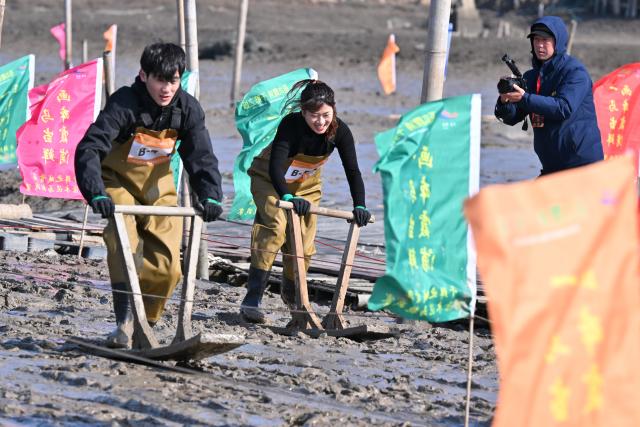 (260208) -- XIAPU, Feb. 8, 2026 (Xinhua) -- People attend a "munima" racing competition in Xiapu County, southeast China's Fujian Province, Feb. 8, 2026. "Munima," meaning "wooden mud horse" in Chinese, is a traditional sled-like tool for gliding over tidal flats to pick up seafood. Horse-themed tourism has surged recently in Xiapu County as the lunar Year of the Horse approaches. (Xinhua/Jiang Kehong)
