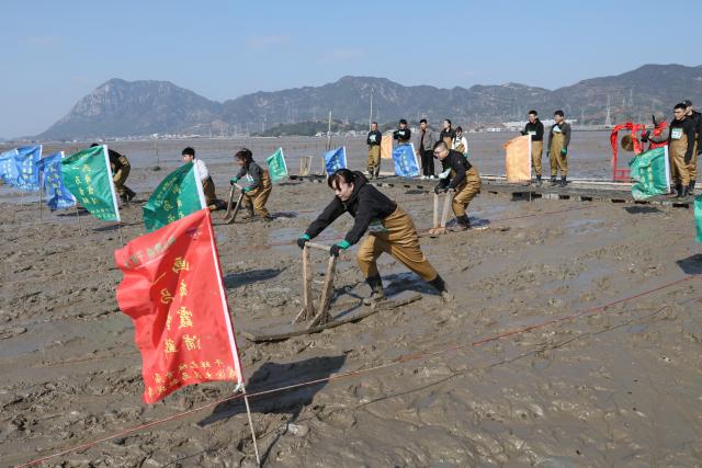 (260208) -- XIAPU, Feb. 8, 2026 (Xinhua) -- People attend a "munima" racing competition in Xiapu County, southeast China's Fujian Province, Feb. 8, 2026. "Munima," meaning "wooden mud horse" in Chinese, is a traditional sled-like tool for gliding over tidal flats to pick up seafood. Horse-themed tourism has surged recently in Xiapu County as the lunar Year of the Horse approaches. (Xinhua/Jiang Kehong)