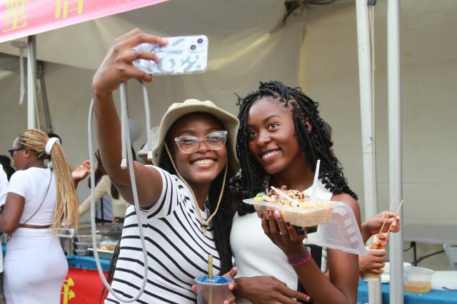 (260208) -- HARARE, Feb. 8, 2026 (Xinhua) -- People take selfies at a carnival to celebrate the Chinese New Year in Harare, Zimbabwe, on Feb. 7, 2026. Zimbabweans on Saturday were treated to Chinese cuisine and traditional performances at a carnival held in Harare, Zimbabwe's capital, to celebrate the upcoming Chinese New Year.
   TO GO WITH "Carnival held in Zimbabwe to celebrate Chinese New Year" (Photo by Tafara Mugwara/Xinhua)