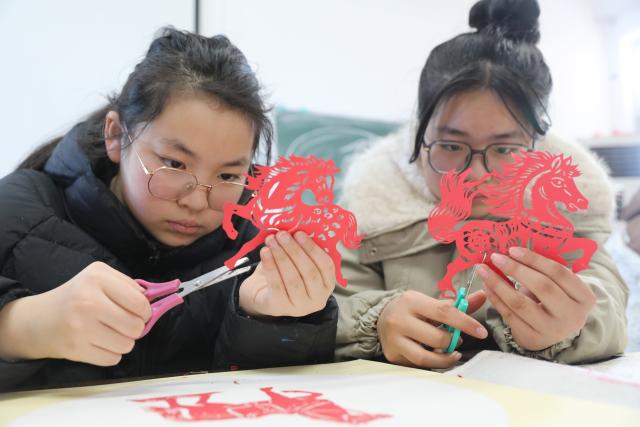 (260208) -- BEIJING, Feb. 8, 2026 (Xinhua) -- Students learn to make paper cuttings in Wenxian County of Jiaozuo, central China's Henan Province, on Feb. 8, 2026. Various extracurricular activities are available for students across China during the winter vacation. (Photo by Xu Hongxing/Xinhua)