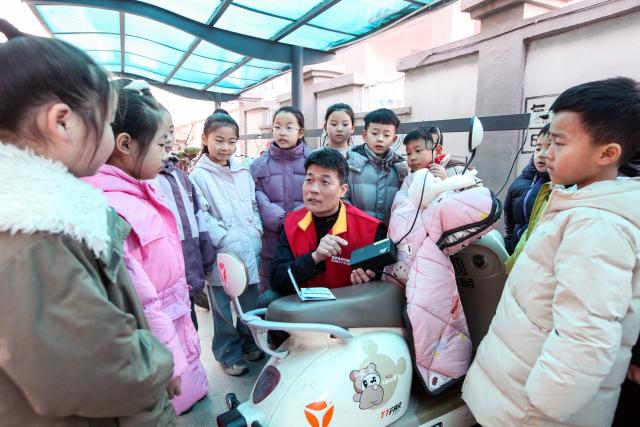 (260208) -- BEIJING, Feb. 8, 2026 (Xinhua) -- A power supply worker explains electricity usage knowledge to students at a primary school in Bo'ai County of Jiaozuo, central China's Henan Province, on Feb. 5, 2026. Various extracurricular activities are available for students across China during the winter vacation. (Photo by Cheng Quan/Xinhua)