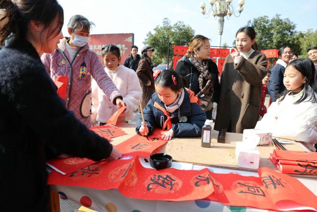 (260208) -- BEIJING, Feb. 8, 2026 (Xinhua) -- Students write spring couplets at a primary school in Dongyang, east China's Zhejiang Province, on Feb. 8, 2026. Various extracurricular activities are available for students across China during the winter vacation. (Photo by Bao Kangxuan/Xinhua)
