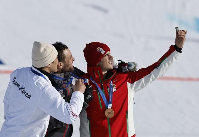 (260208) -- LIVIGNO, Feb. 8, 2026 (Xinhua) -- Gold medalist Benjamin Karl (C) of Austria, silver medalist Kim Sangkyum (L) of South Korea and bronze medalist Tervel Zamfirov of Bulgaria take selfies after the Snowboard Men's Parallel Giant Slalom final at the Milan-Cortina 2026 Olympic Winter Games in Livigno, Italy, Feb. 8, 2026. (Xinhua/Wang Peng)