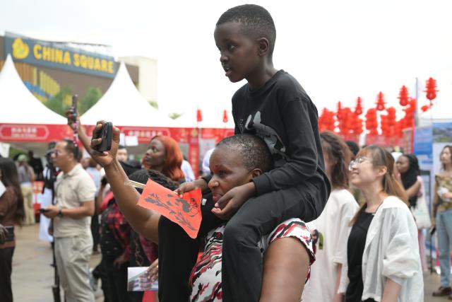 (260208) -- NAIROBI, Feb. 8, 2026 (Xinhua) -- A woman takes photos as she watches a performance with her son at the 2026 Chinese New Year Gala in Nairobi, Kenya, Feb. 8, 2026. Kenya on Sunday celebrated the 2026 Chinese New Year Gala in Nairobi, bringing together dignitaries including senior government officials, diplomats, industry leaders, and hundreds of local and foreign visitors.
   The day-long event, held at Two Rivers Mall, featured cultural performances such as dragon and lion dances, contemporary music, and showcases of Chinese costumes and cuisine. (Xinhua/Yang Guang)