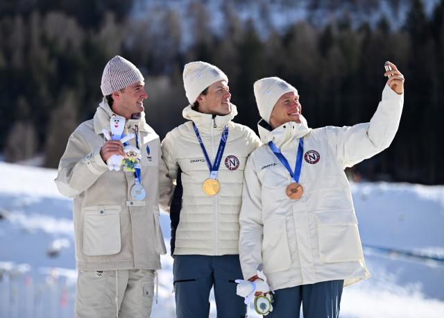 (260208) -- TESERO, Feb. 8, 2026 (Xinhua) -- Gold medalist Johannes Hoesflot Klaebo (C) of Norway, silver medalist Mathis Desloges (L) of France and bronze medalist Martin Loewstroem Nyenget of Norway take a selfie during the awarding ceremony of the cross-country skiing men's 10km+10km skiathlon at the Milan-Cortina 2026 Olympic Winter Games in Tesero, Italy, Feb. 8, 2026. (Xinhua/He Canling)