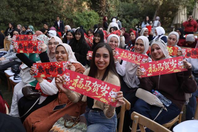 (260209) -- CAIRO, Feb. 9, 2026 (Xinhua) -- People pose for photos with Spring Festival decorations during a 2026 Chinese Spring Festival celebration in Cairo, Egypt, on Feb. 8, 2026. Cairo's Swiss Club hosted celebrations on Sunday for the 2026 Chinese Spring Festival, welcoming the Year of the Horse with food, art and performances that drew nearly 1,000 Egyptians and more than 200 Chinese residents. TO GO WITH "Cultural fusion marks "Year of the Horse" celebrations in Cairo" (Xinhua/Ahmed Gomaa)