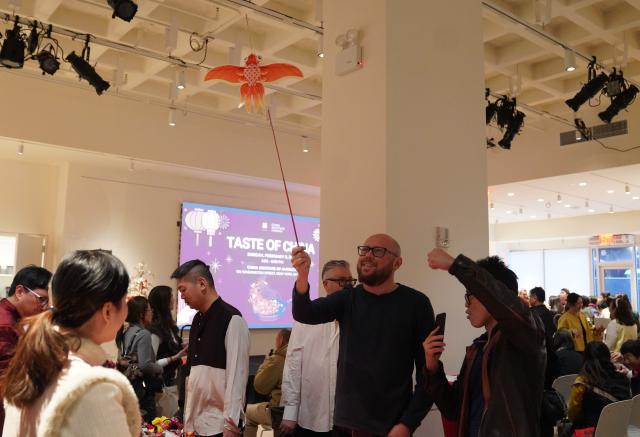 (260209) -- NEW YORK, Feb. 9, 2026 (Xinhua) -- A man learns to fly a kite during the Taste of China cultural event in New York, the United States, on Feb. 8, 2026. A cultural event titled the Taste of China was held here on Sunday to celebrate the Chinese New Year. (Xinhua/Zhang Fengguo)