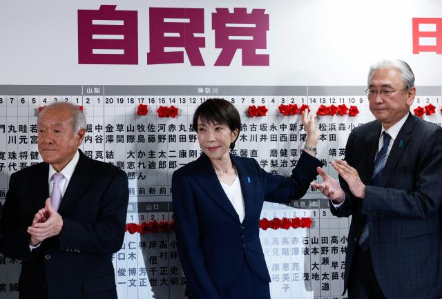 (260209) -- BEIJING, Feb. 9, 2026 (Xinhua) -- Japanese Prime Minister Sanae Takaichi (C), leader of Japan's ruling Liberal Democratic Party (LDP), places red flowers symbolizing success onto names of candidates at the headquarters of the LDP in Tokyo, Japan, Feb. 8, 2026. Japan's ruling coalition of the LDP and the Japan Innovation Party (JIP) won more than a two-thirds majority in the House of Representatives following Sunday's general election, public broadcaster NHK reported early Monday. (Kim Kyung-Hoon/Pool via Xinhua)