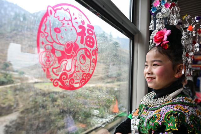 (260209) -- KAILI, Feb. 9, 2026 (Xinhua) -- A passenger is pictured on the train No. 5640 in southwest China's Guizhou Province on Feb. 8, 2026. The train No. 5640 runs in Guizhou Province between Yuping Dong Autonomous County of Tongren City and provincial capital Guiyang City. It connects more than 100 ethnic minority villages along the route and makes travel more convenient for the villagers.
   A New Year market has been introduced on the train No. 5640 upon the upcoming Chinese New Year, during which fresh agricultural products and folk customs were displayed for passengers along the way. (Xinhua/Yang Wenbin)
