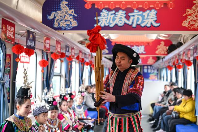 (260209) -- KAILI, Feb. 9, 2026 (Xinhua) -- An actor plays Lusheng, a traditional reed-pipe wind instrument, on the train No. 5640 in southwest China's Guizhou Province on Feb. 8, 2026. The train No. 5640 runs in Guizhou Province between Yuping Dong Autonomous County of Tongren City and provincial capital Guiyang City. It connects more than 100 ethnic minority villages along the route and makes travel more convenient for the villagers.
   A New Year market has been introduced on the train No. 5640 upon the upcoming Chinese New Year, during which fresh agricultural products and folk customs were displayed for passengers along the way. (Xinhua/Yang Wenbin)