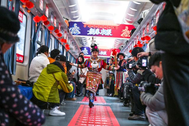 (260209) -- KAILI, Feb. 9, 2026 (Xinhua) -- A child displays ethnic costumes on the train No. 5640 in southwest China's Guizhou Province on Feb. 8, 2026. The train No. 5640 runs in Guizhou Province between Yuping Dong Autonomous County of Tongren City and provincial capital Guiyang City. It connects more than 100 ethnic minority villages along the route and makes travel more convenient for the villagers.
   A New Year market has been introduced on the train No. 5640 upon the upcoming Chinese New Year, during which fresh agricultural products and folk customs were displayed for passengers along the way. (Xinhua/Yang Wenbin)